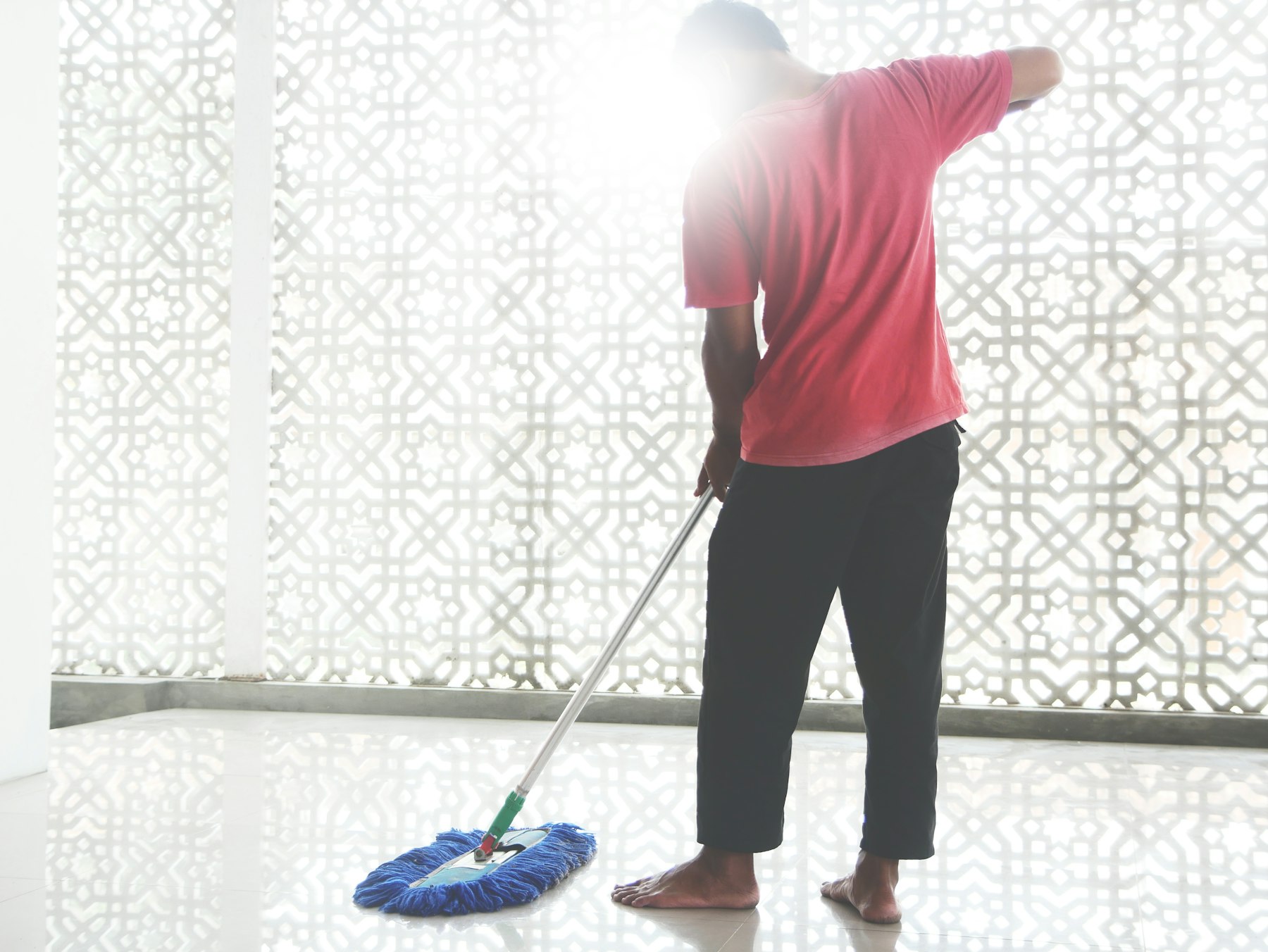 Housekeeper mopping a bright floor